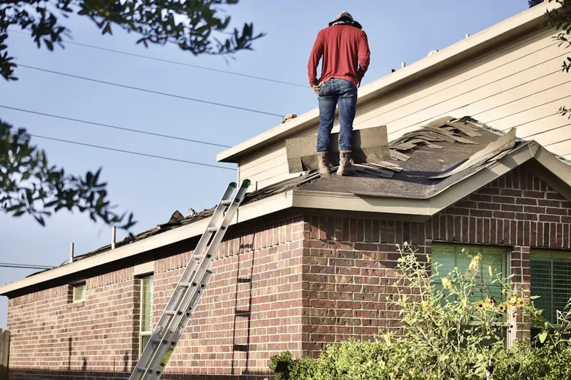 Professional roofer working on a residential roof in Dale